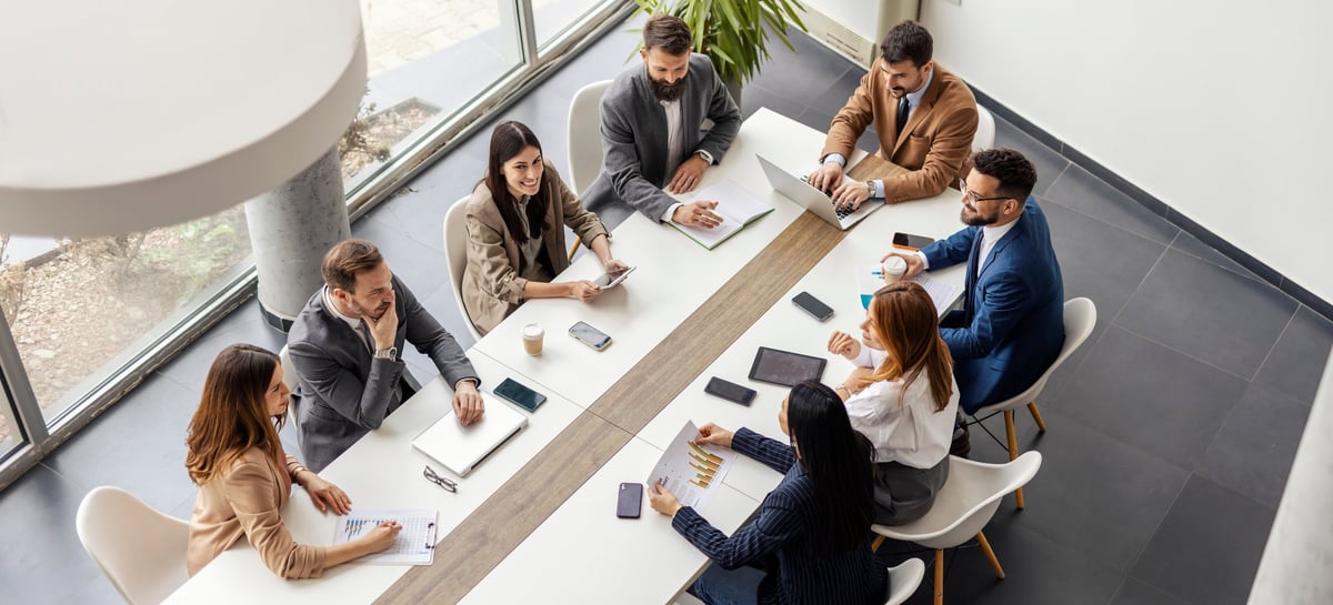 From above view of leadership team sitting at conference table and having meeting