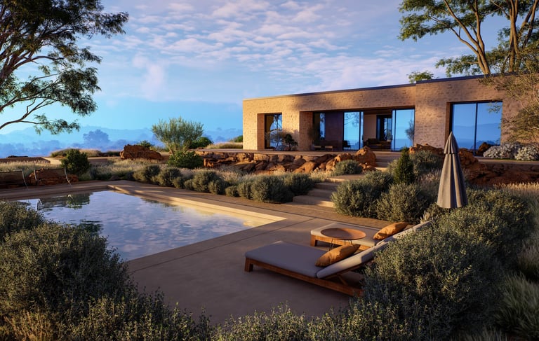 Horizontal view of a contemporary stone villa featuring a luxury swimming pool, lounge chairs, and desert landscaping under a warm sunset sky.