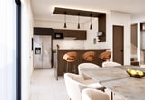 Modern open-concept kitchen and dining area with brown cabinetry, kitchen island with bar seating, pendant lights, and marble dining table