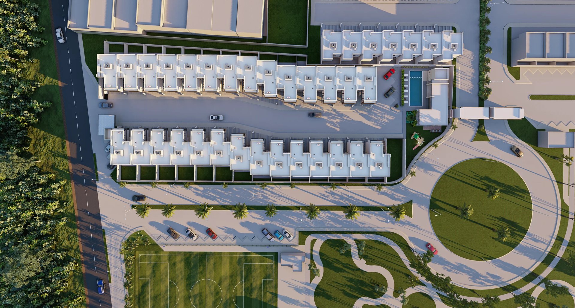 Aerial view of a modern residential complex with white townhouses, green landscaped grounds, and circular plaza design