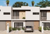 Modern white townhouses with flat roofs, large windows, and a parked car in the driveway under a blue sky with palm trees in the background