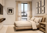 Modern bedroom with light wood bed, beige bedding, framed wall art, floor-to-ceiling window with curtains, and wooden nightstand