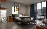 Modern bedroom with king-size bed, dark nightstand, large windows with city view, and minimalist decor