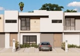 Modern townhouses with white and beige exterior, integrated carports, and contemporary architecture under blue sky